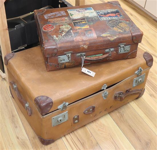 A red leather lined suitcase with 1930s labels, a trunk and laundry box